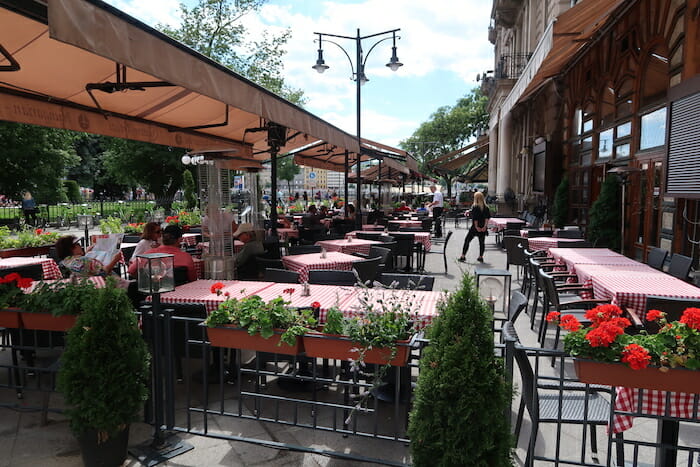 a group of people sitting at tables outside