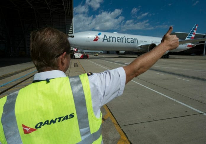 a man in a safety vest pointing at an airplane