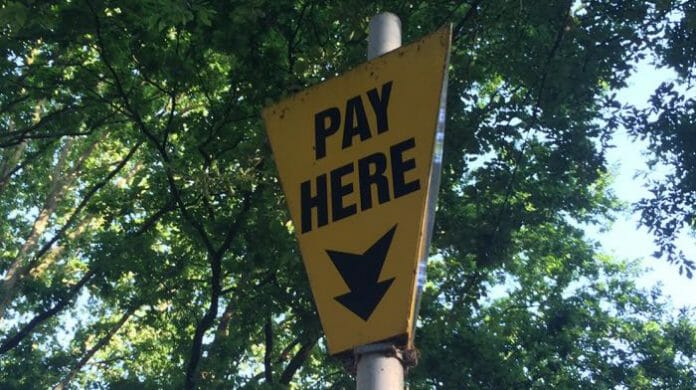 a yellow sign with black text and arrow on it