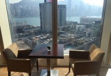a table and chairs in a room with a view of a city and water