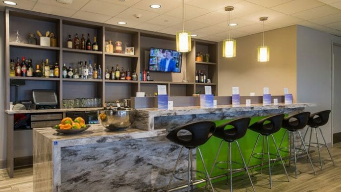 a bar with a counter and shelves with bottles and a television