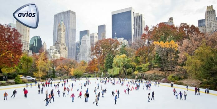 a group of people ice skating in a park with Central Park in the background