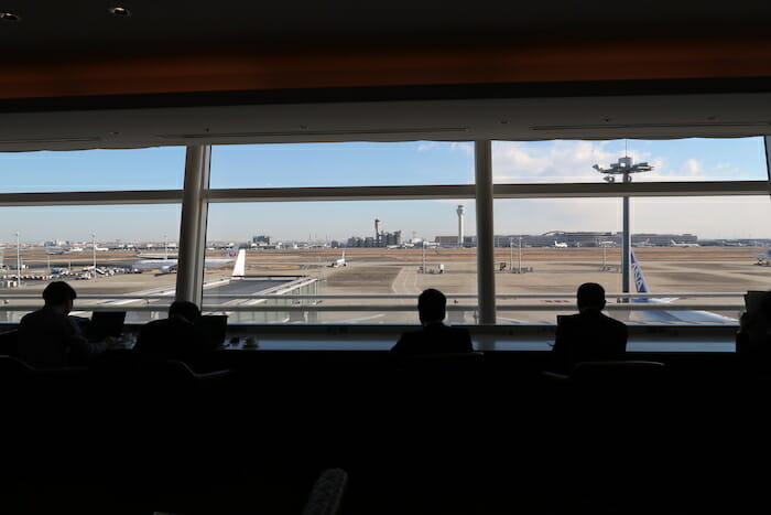 people sitting in a room with a window and a runway