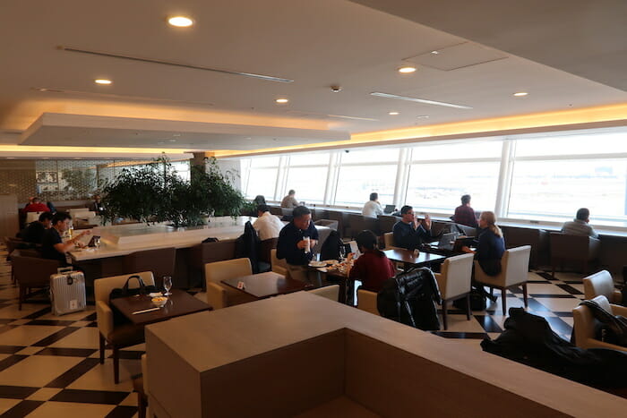 a group of people sitting at tables in a room with windows