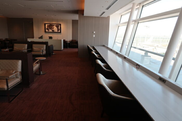 a long table with chairs in a room with a window