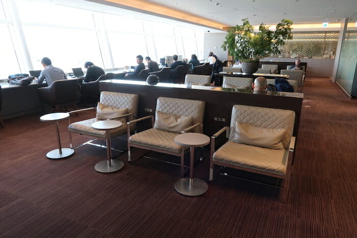 a group of people sitting in a room with chairs and tables