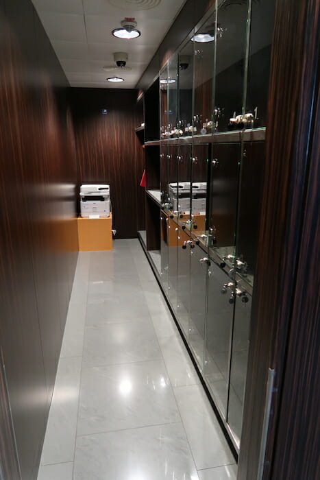 a hallway with glass cabinets and a white tile floor