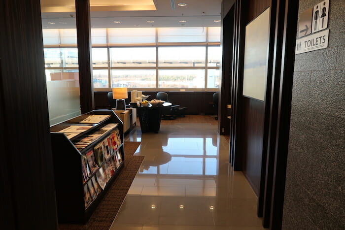 a hallway with a book shelf and a large window