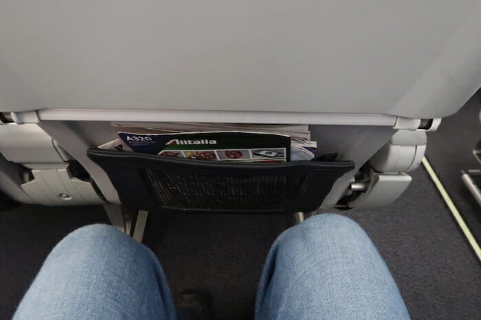 a person's legs and a pocket in an airplane