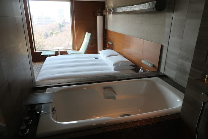 a white bathtub next to a bed