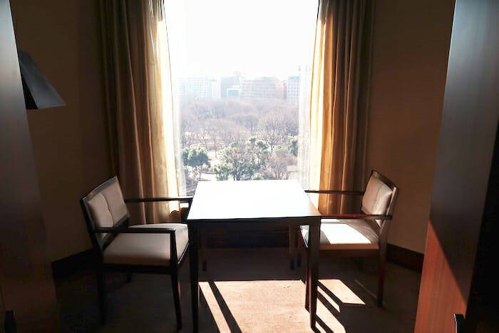 a table and chairs in a room with a window