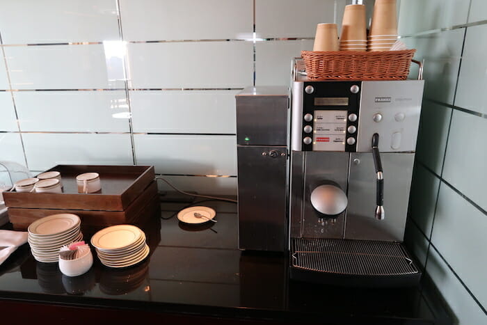 a coffee machine with a basket of cups on top of it