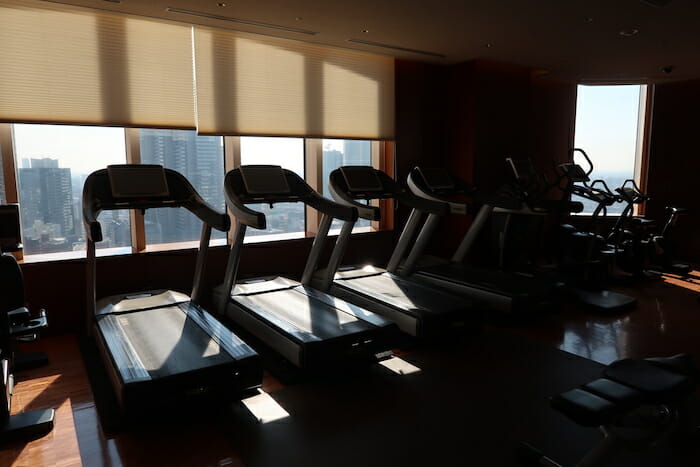 a group of treadmills in a room with windows