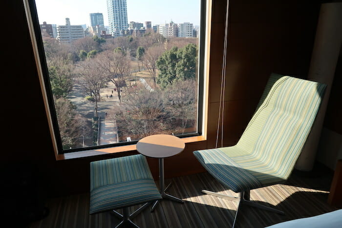 a chair and table in a room with a view of a city