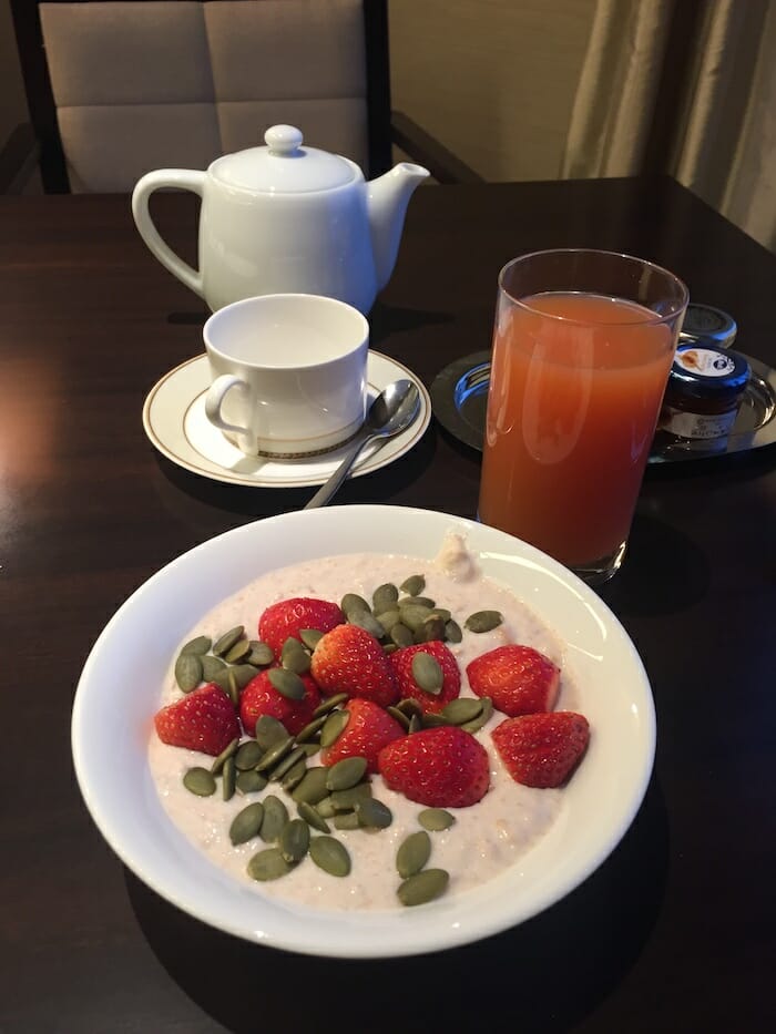 a bowl of oatmeal with strawberries and seeds on a table