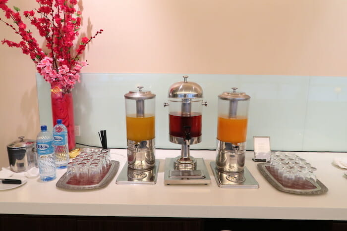 a group of juice dispensers on a table