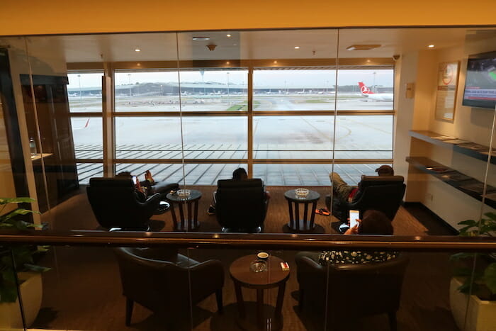 people sitting in chairs in a room with a window