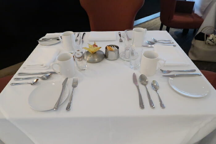 a table with white plates and silverware