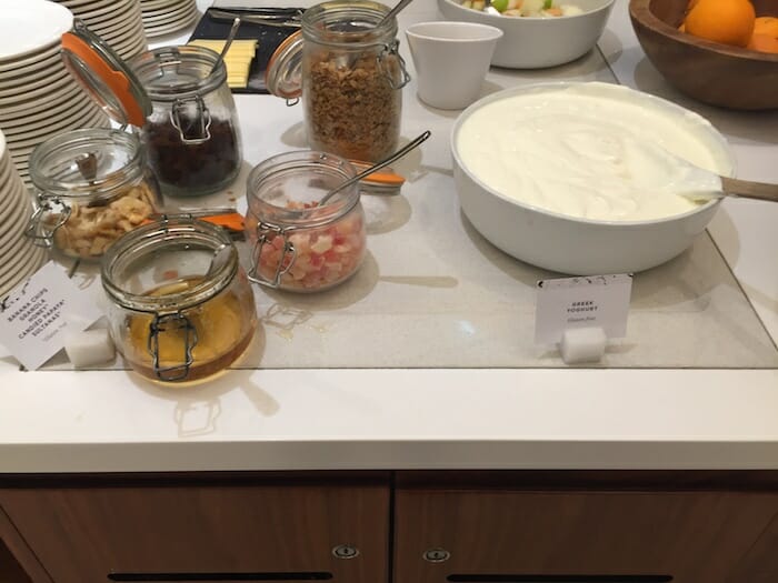 a white bowl of yogurt and a bowl of food on a counter