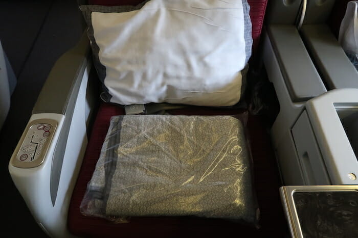 a pillow and blanket on a seat