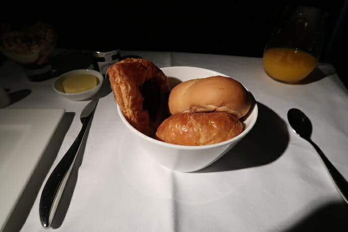 a bowl of bread and buns on a table