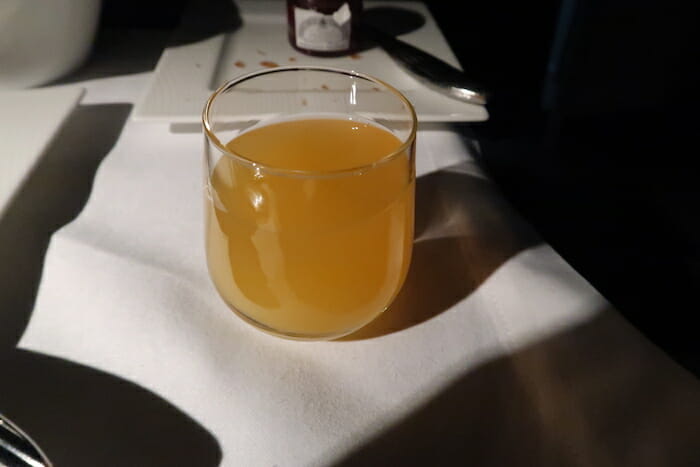 a glass of orange liquid on a table