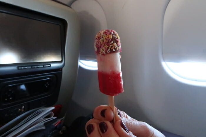 a hand holding a popsicle with sprinkles