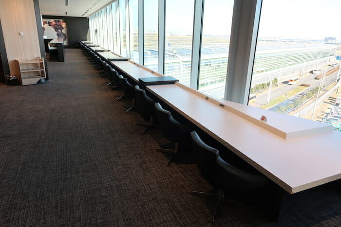 a long table with chairs in a room with windows