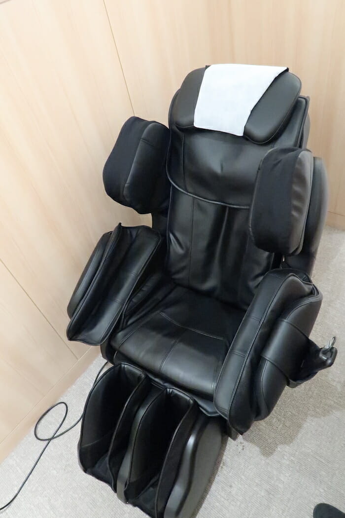 a black massage chair with a white napkin on top