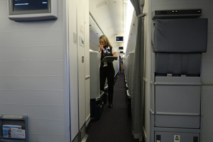 a woman standing in a hallway of an airplane