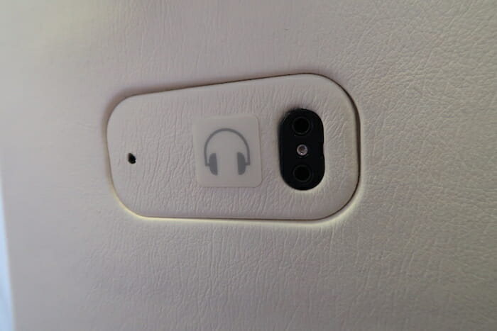 a phone camera and headphones on a white surface