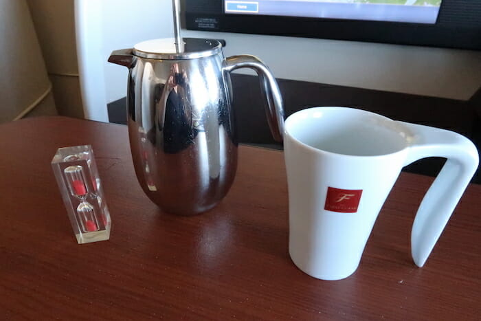 a coffee pot and a white mug on a table