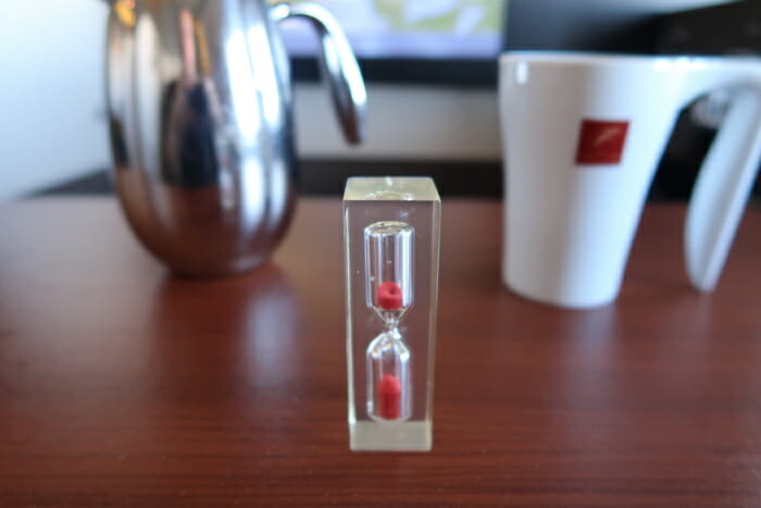 a clear hourglass with red sand inside