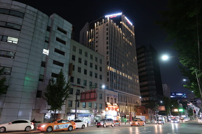 a city street with cars and buildings at night