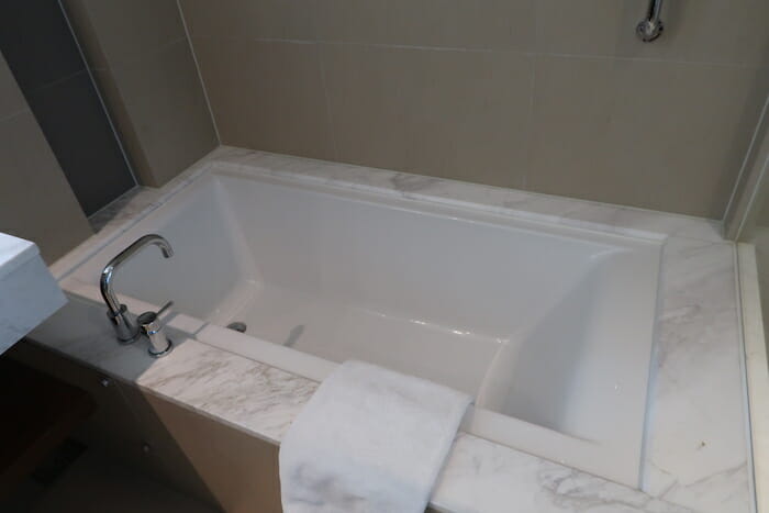 a bathtub with a white towel on the edge