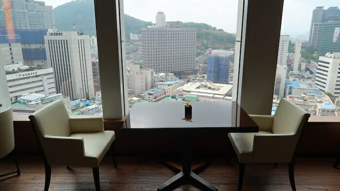 a table and chairs in a room with a view of a city