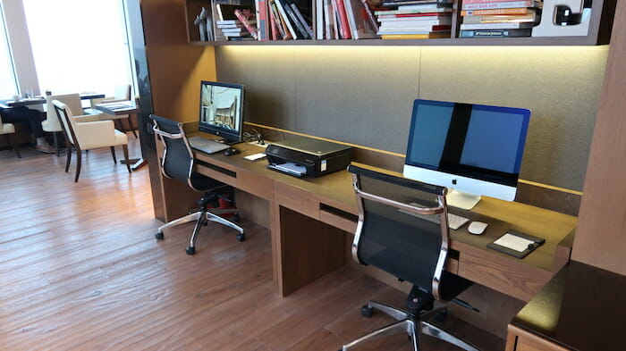 a desk with two computers and a printer