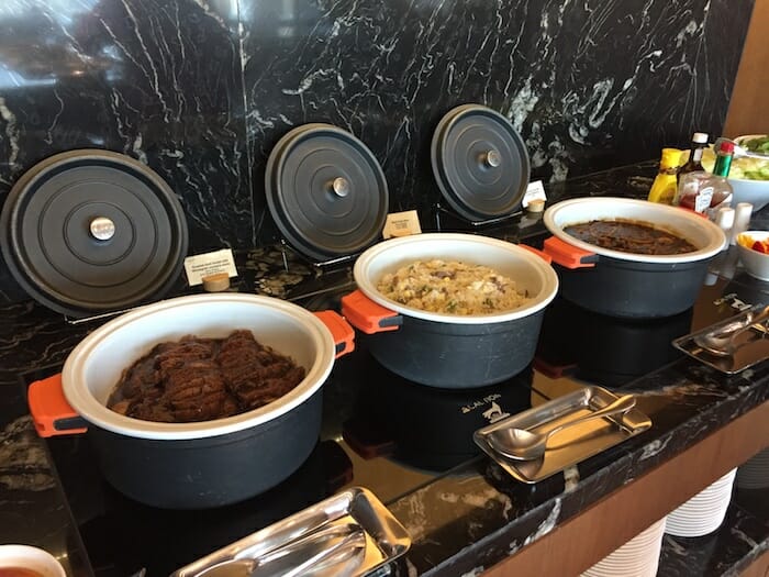 a row of bowls of food on a counter