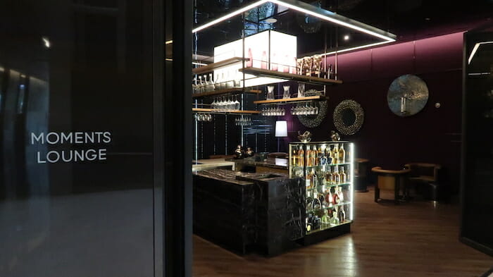 a room with a bar and shelves of wine glasses