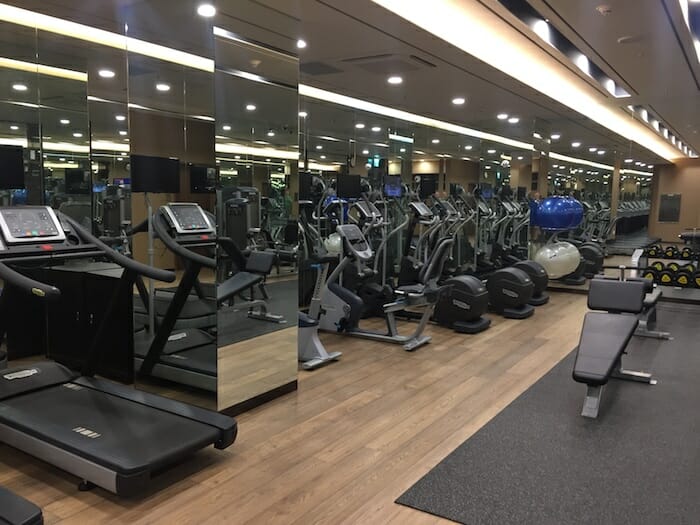 a room with a large mirror wall and exercise equipment