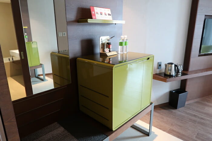 a green cabinet with a mirror and a shelf