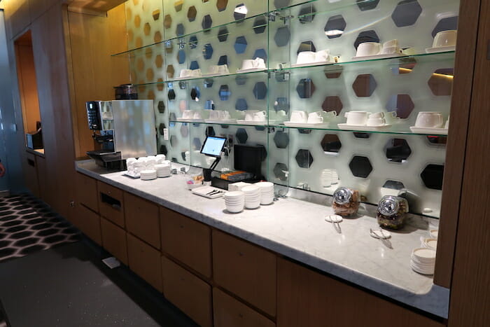 a counter with a counter and shelves with white cups and coffee