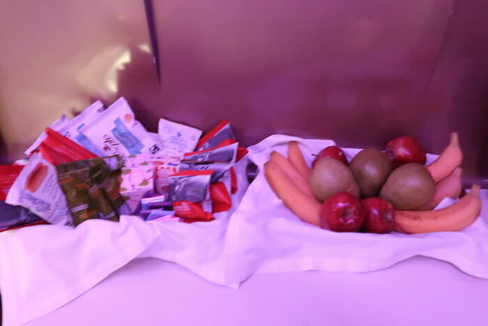 a bowl of fruit and vegetables on a white surface