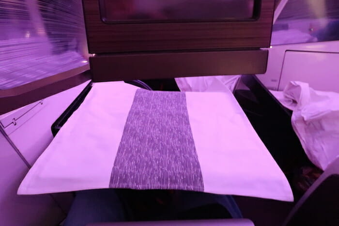 a white pillow with purple stripe on it