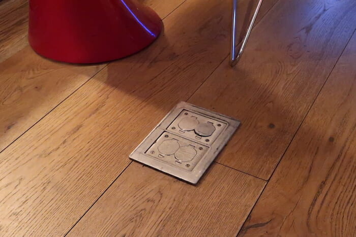 a metal outlet on a wood floor