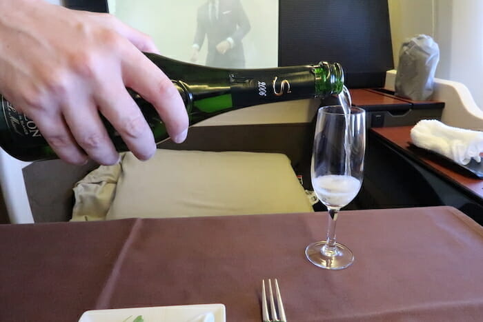 a person pouring a glass of champagne