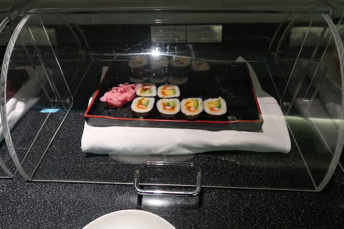 a tray of sushi on a black surface