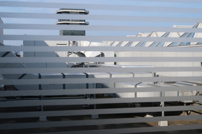 a window with blinds and a building behind it