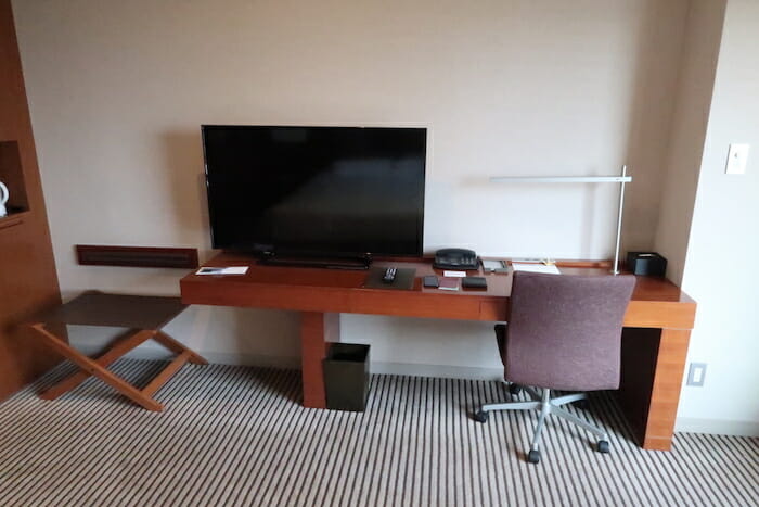 a desk with a television and chairs