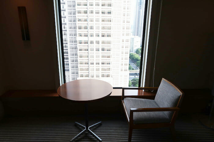 a table and chair in a room with a large window